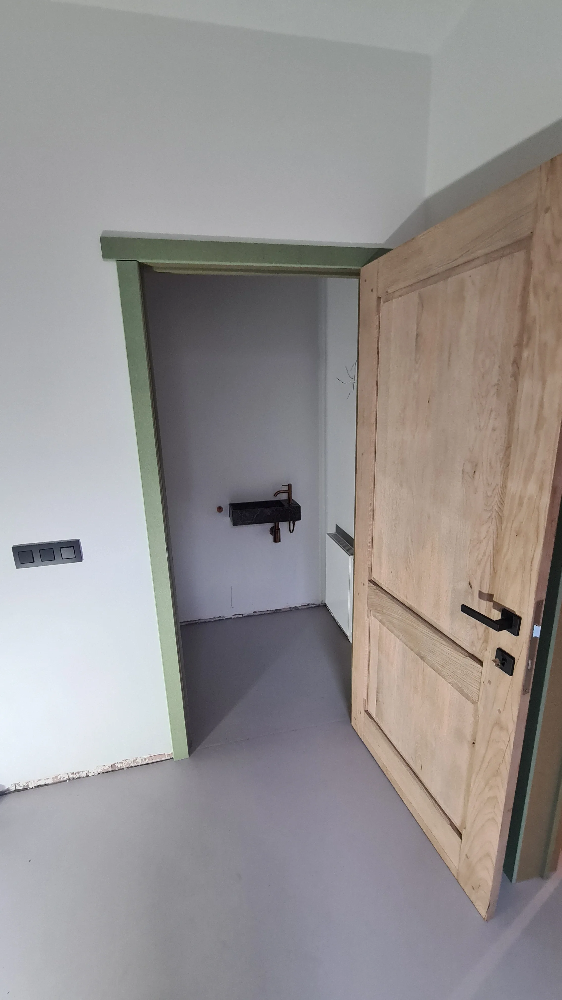 Detail van de nieuwe scharnieren en klinken op een gerestaureerde eiken deur