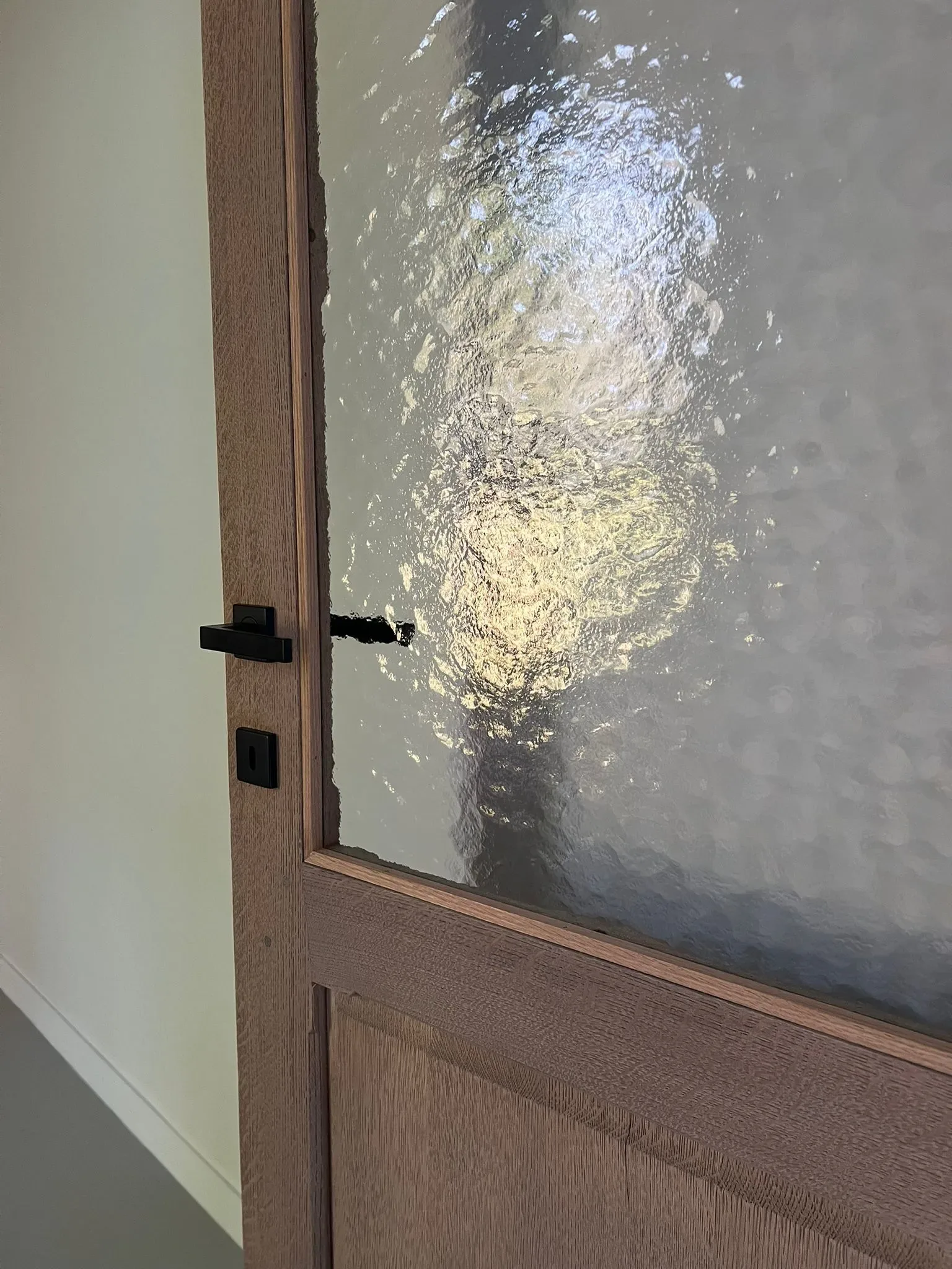 Detail van het nieuwe kathedraalglas en de nieuwe zwarte deurklink
